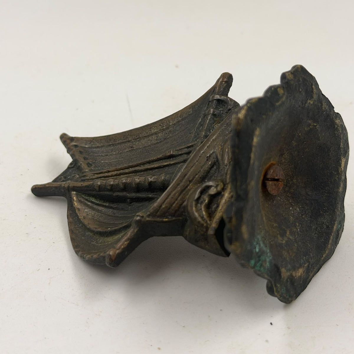 Antique brass sailboat figurine – held in hand, front view