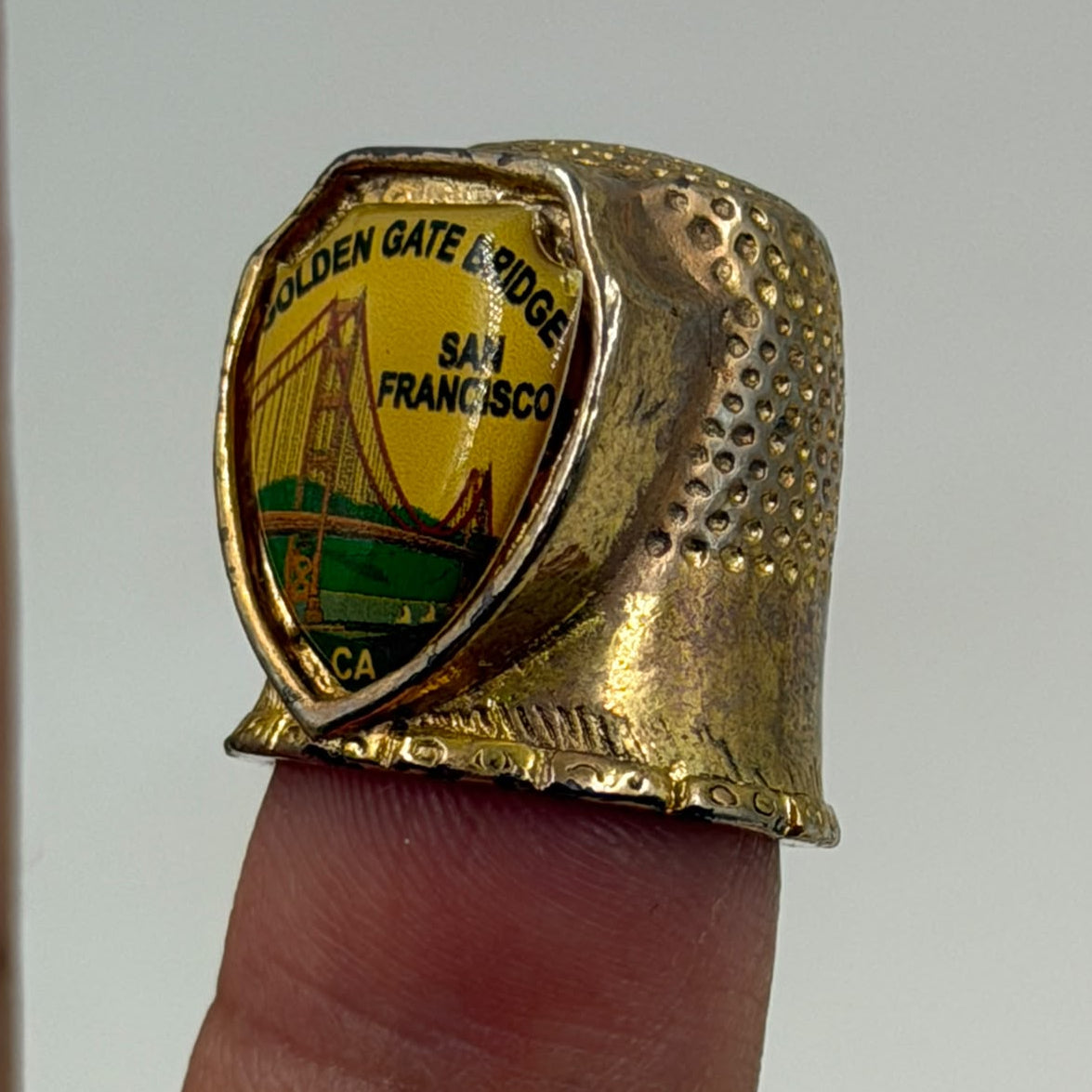 Vintage FORT USA gold thimble Golden Gate Bridge – front view in display case