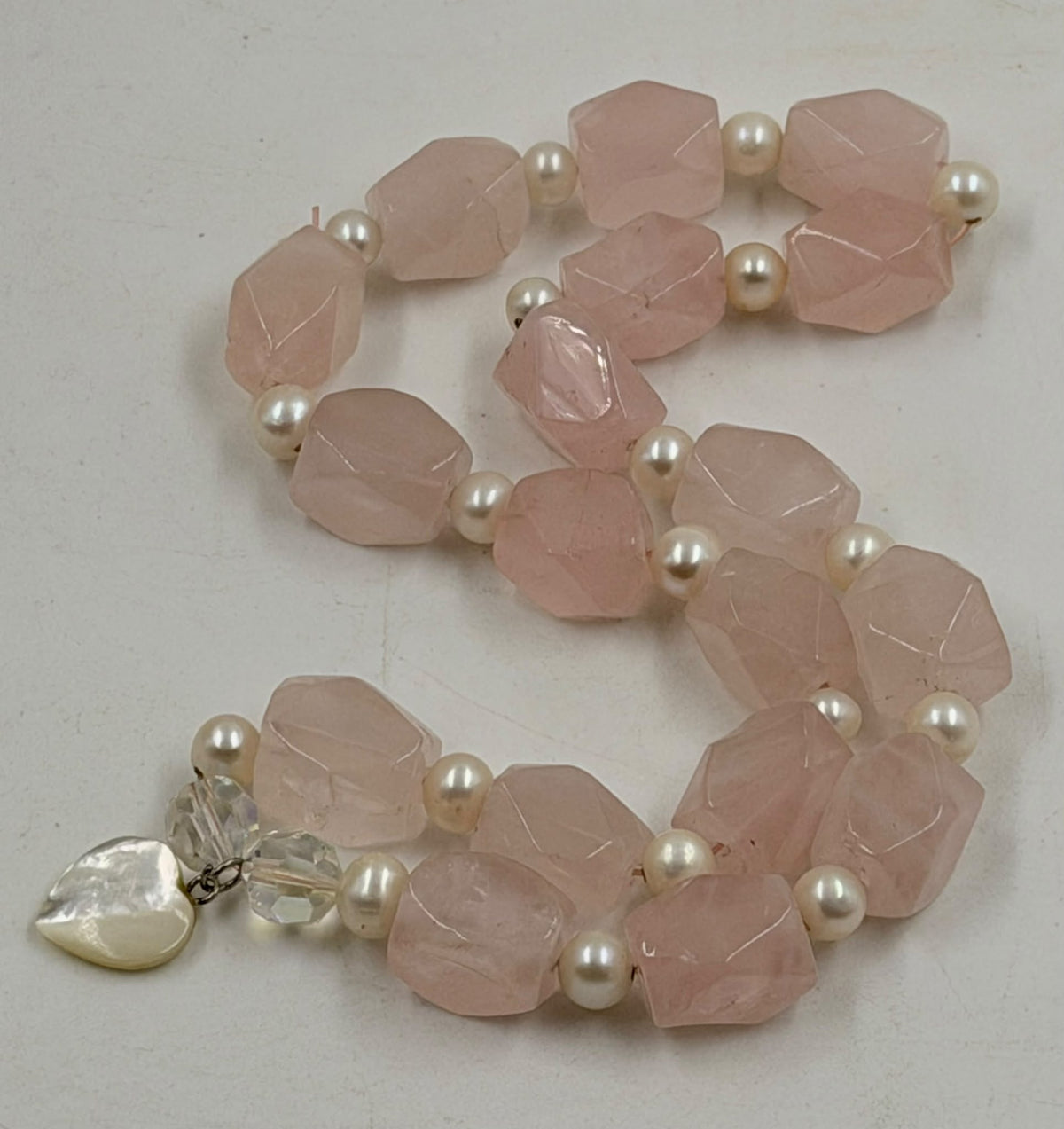 Rose quartz faceted chunks with freshwater pearls close-up
