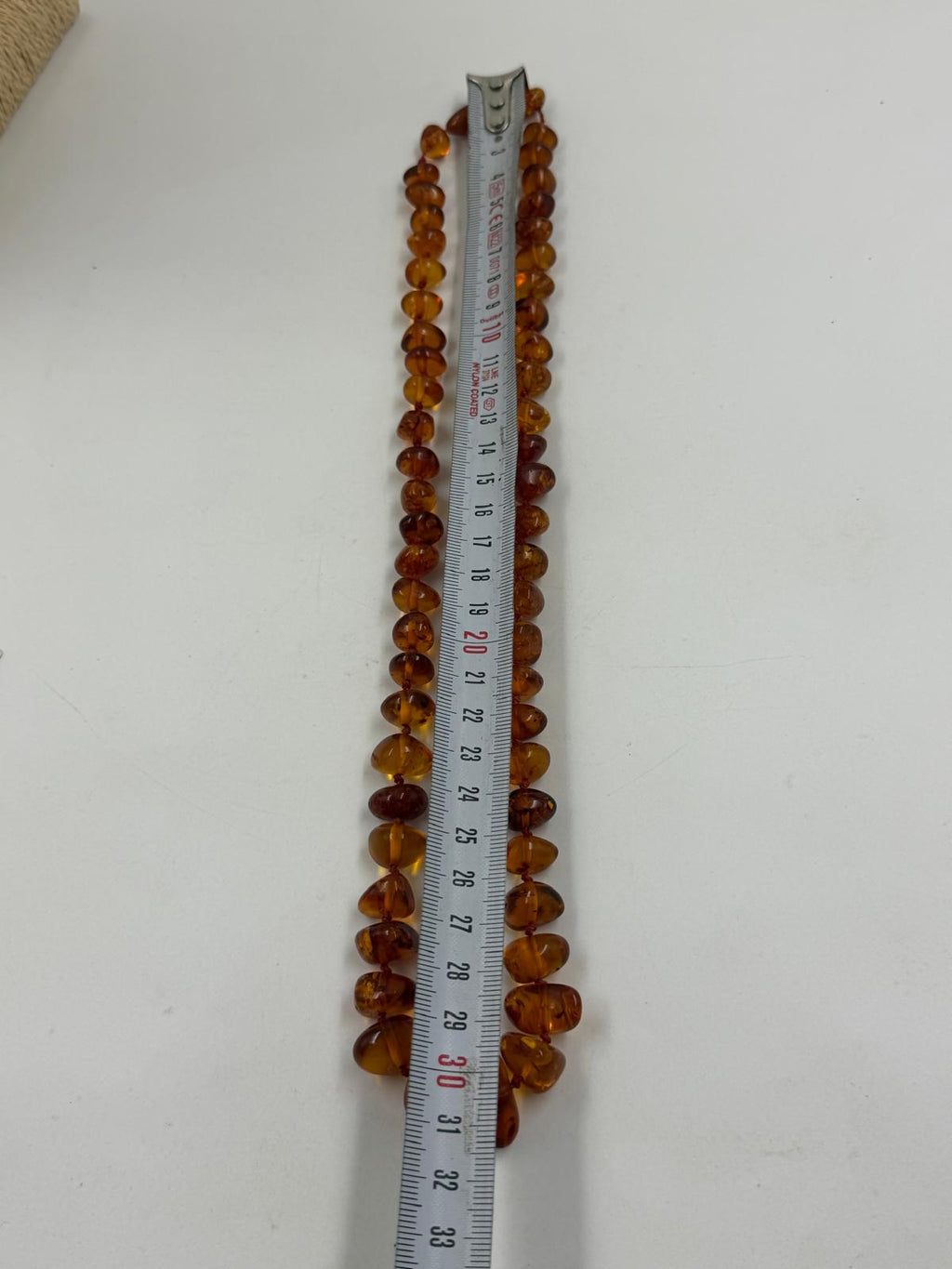 Full amber-like necklace on jewelry display stand