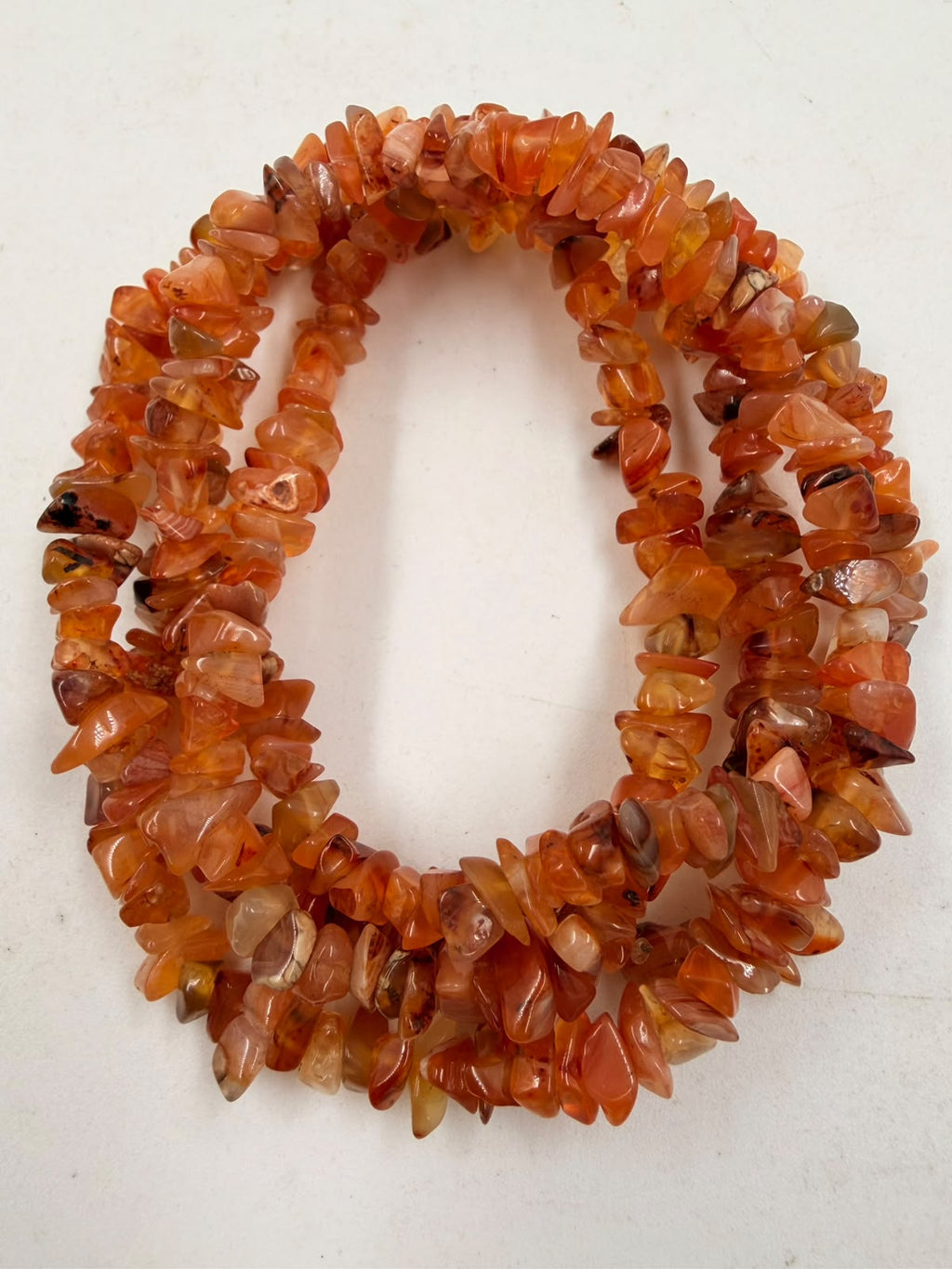 Natural carnelian chip bead necklace macro close-up showing translucent orange chips with amber variations