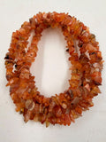 Natural carnelian chip bead necklace macro close-up showing translucent orange chips with amber variations