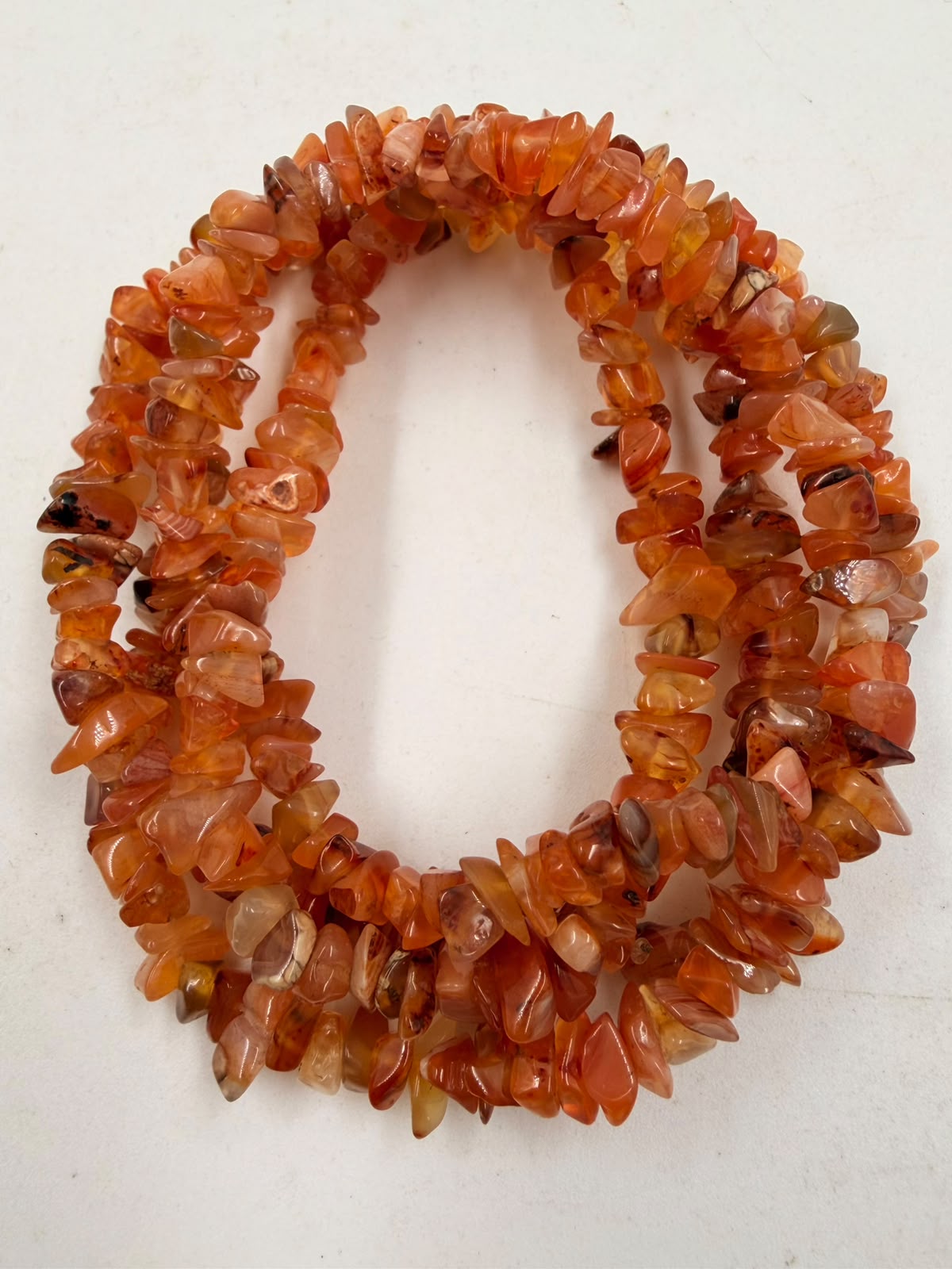 Natural carnelian chip bead necklace macro close-up showing translucent orange chips with amber variations