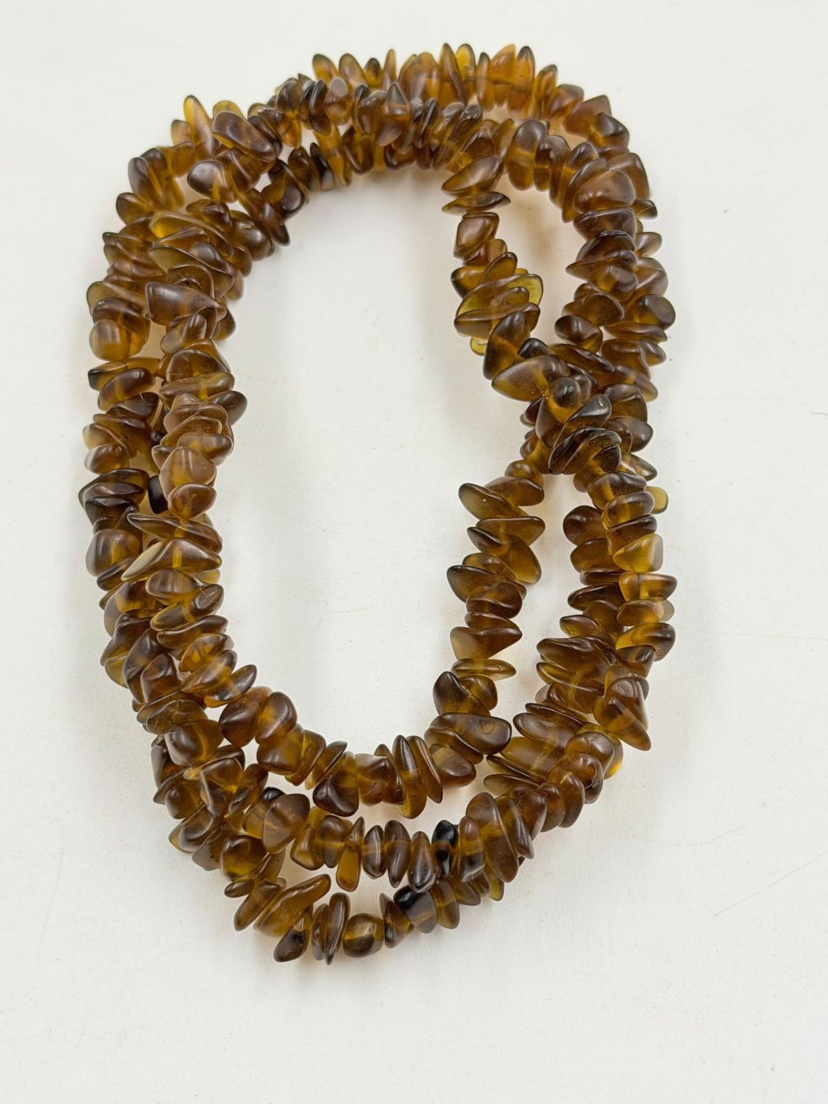 Natural brown agate chips close up showing warm cognac translucent color and texture