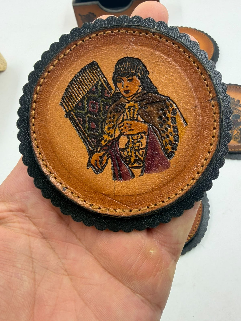 Chilean leather coaster featuring a Mapuche woman weaver