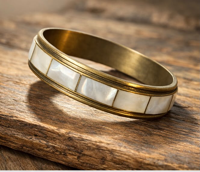 Close-up of mother of pearl tile inlay on brass bangle showing iridescent shimmer