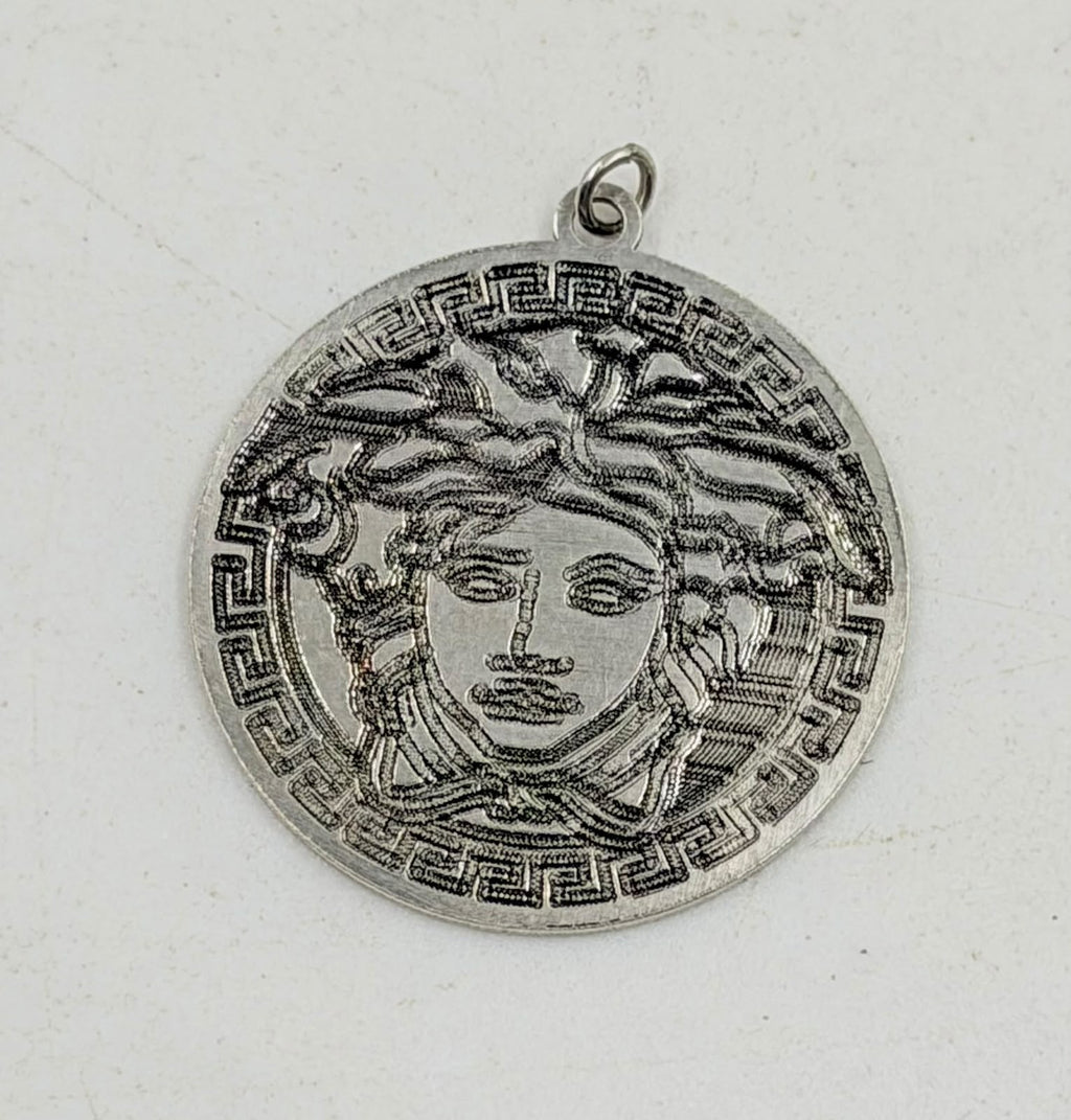 Medusa pendant held in hand showing size and detail