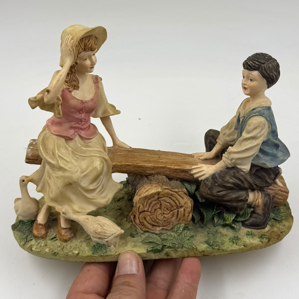 Vintage Victorian resin children seesaw figurine angled front view