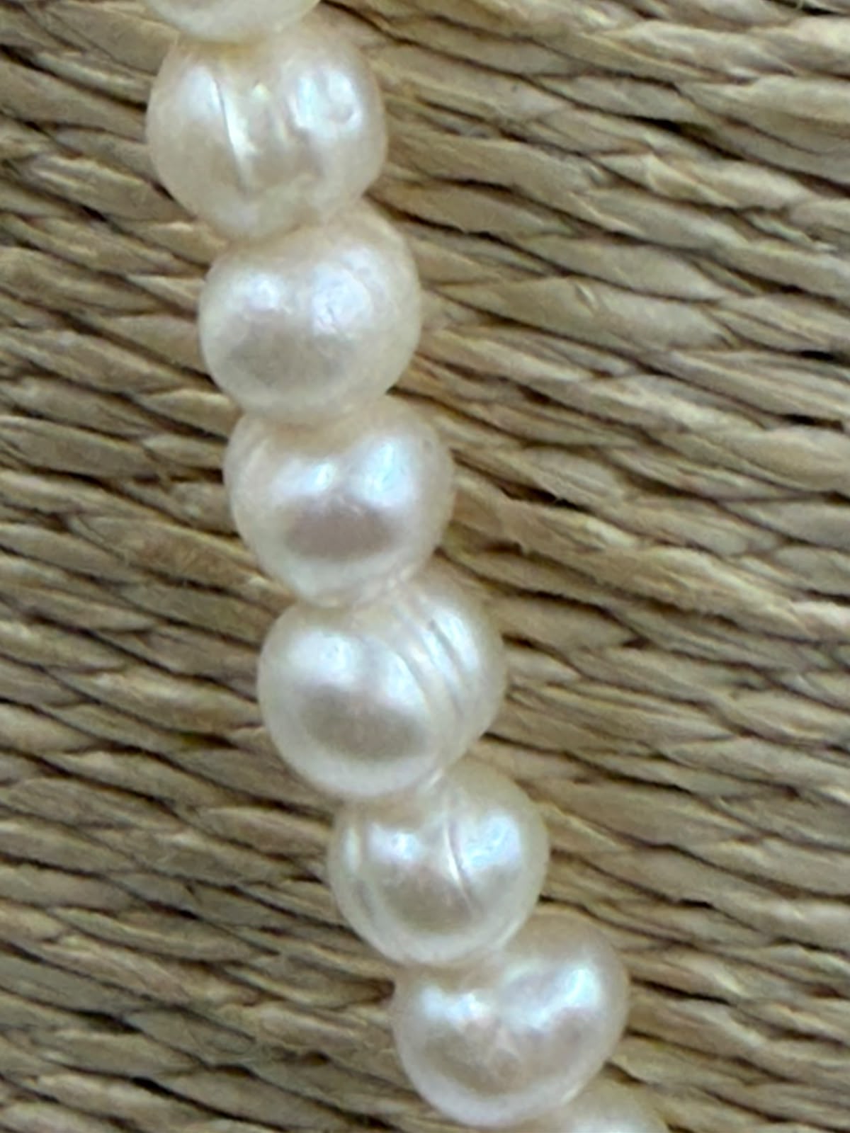 Freshwater pearl necklace on linen bust display showing full 58cm length and natural baroque pearl shape