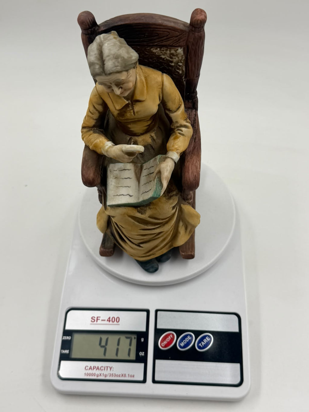 Vintage resin grandma reading figurine side view left showing rocking chair profile