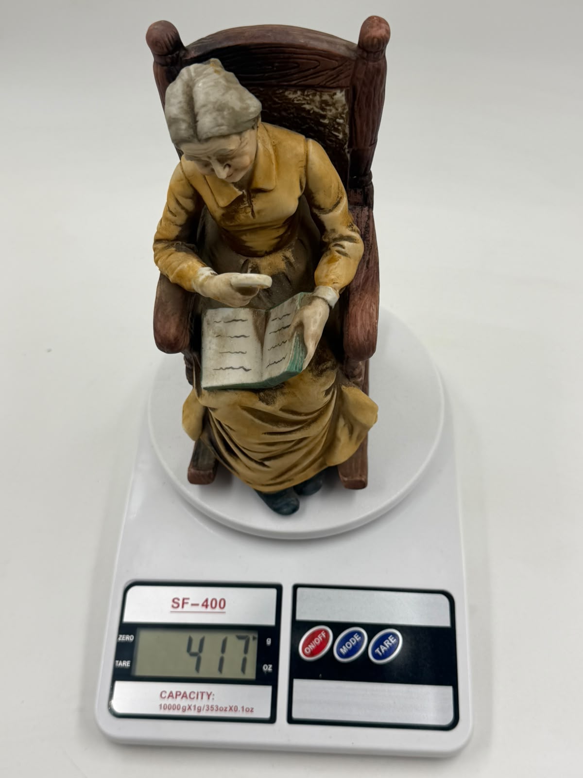 Vintage resin grandma reading figurine side view left showing rocking chair profile