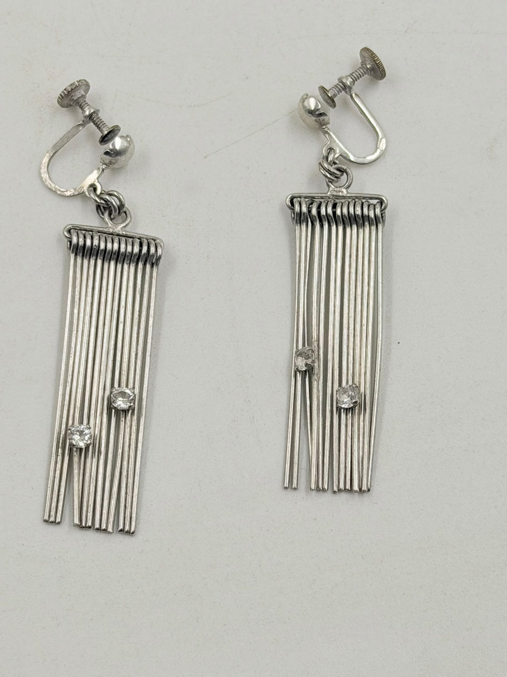 Both earrings splayed open showing wire fan and screw-back detail