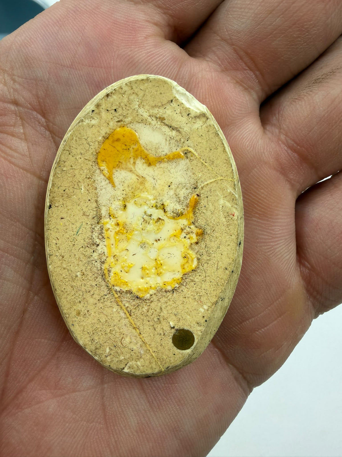 Real scorpion epoxy resin pendant held in open palm lifestyle photo showing scale and cream ivory resin color