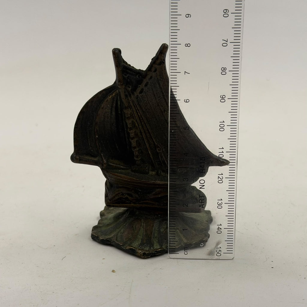 Antique brass sailboat figurine – back view held in hand