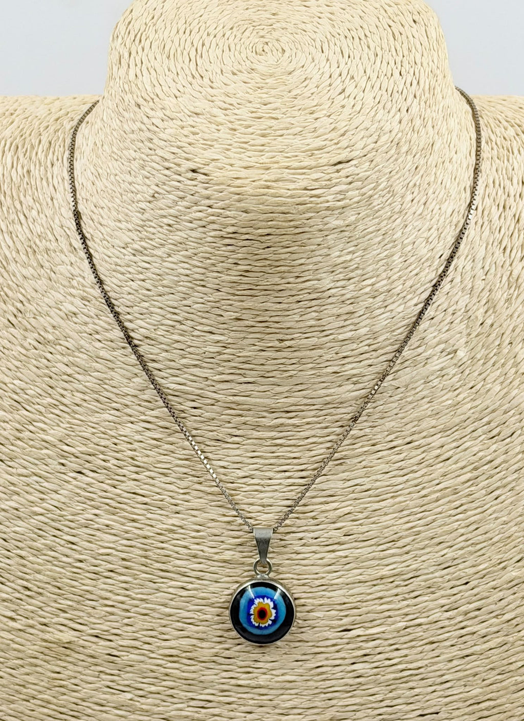 Millefiori evil eye pendant close-up in hand