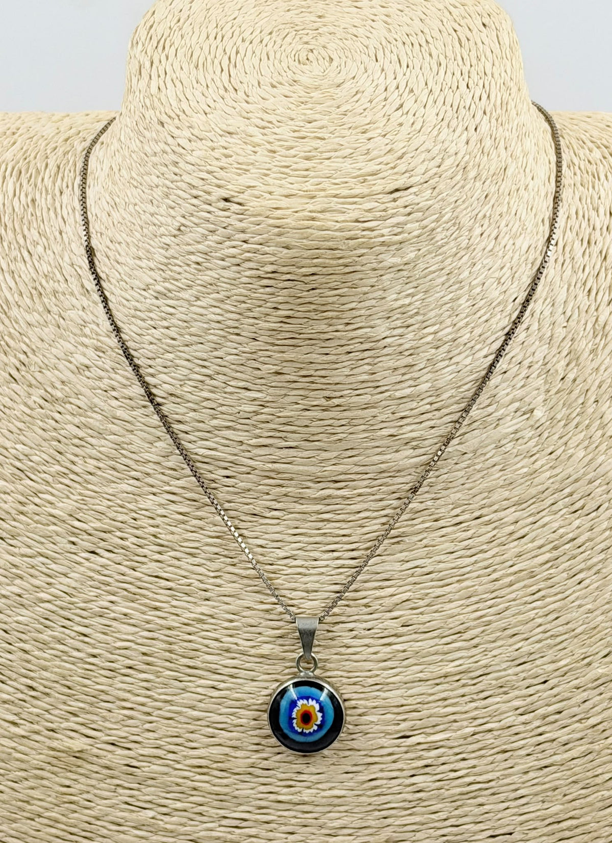 Millefiori evil eye pendant close-up in hand