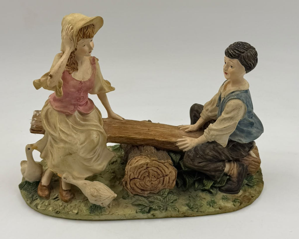 Vintage Victorian resin children seesaw figurine three-quarter view