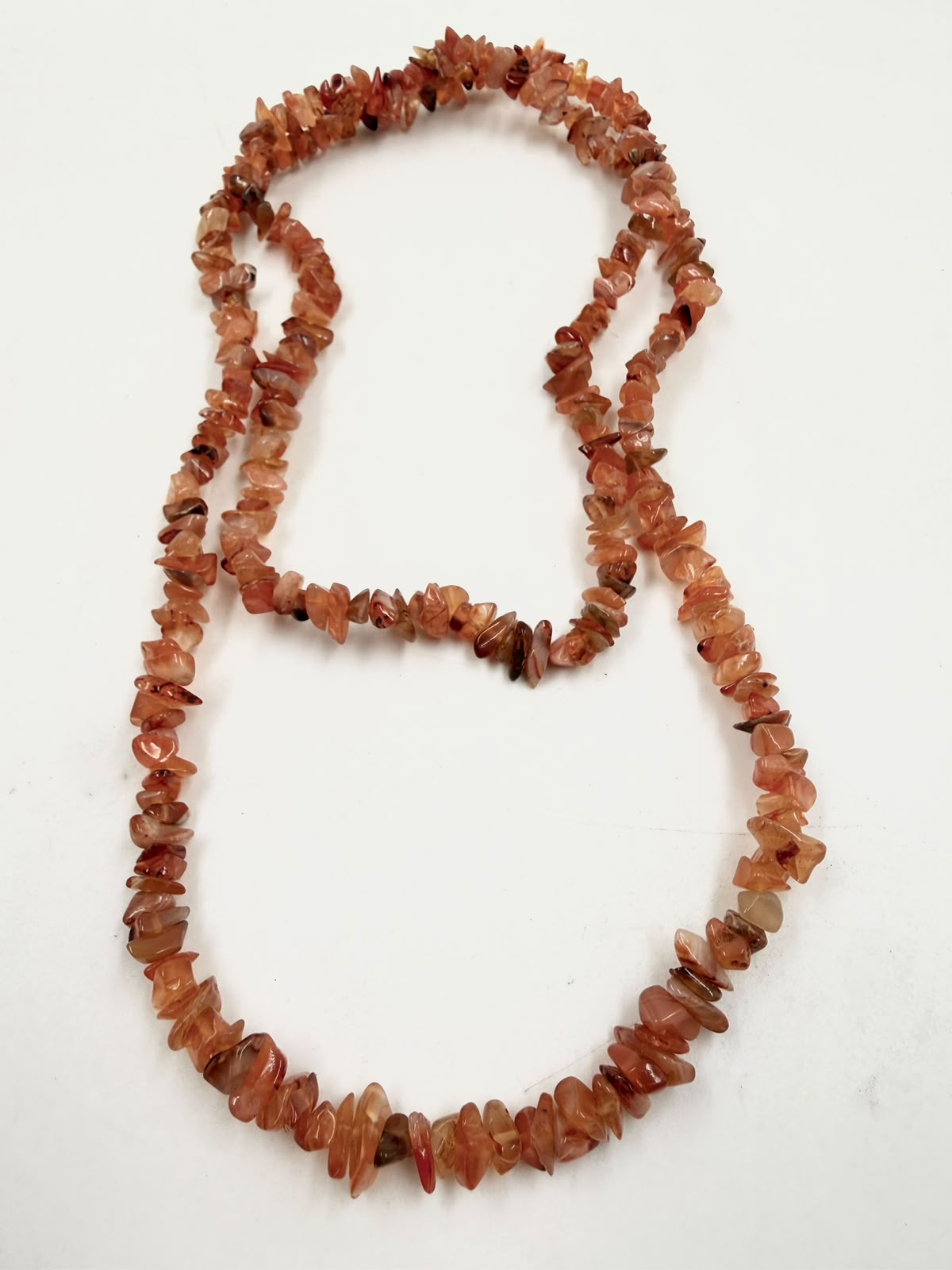 Natural carnelian chip necklace worn as double strand 44cm choker on woven surface