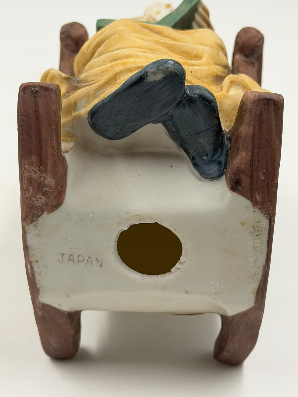 Vintage resin grandma reading figurine back view showing chair back texture