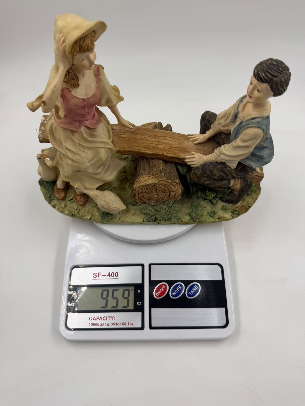 Vintage Victorian resin children seesaw figurine front view with ruler showing 21cm width