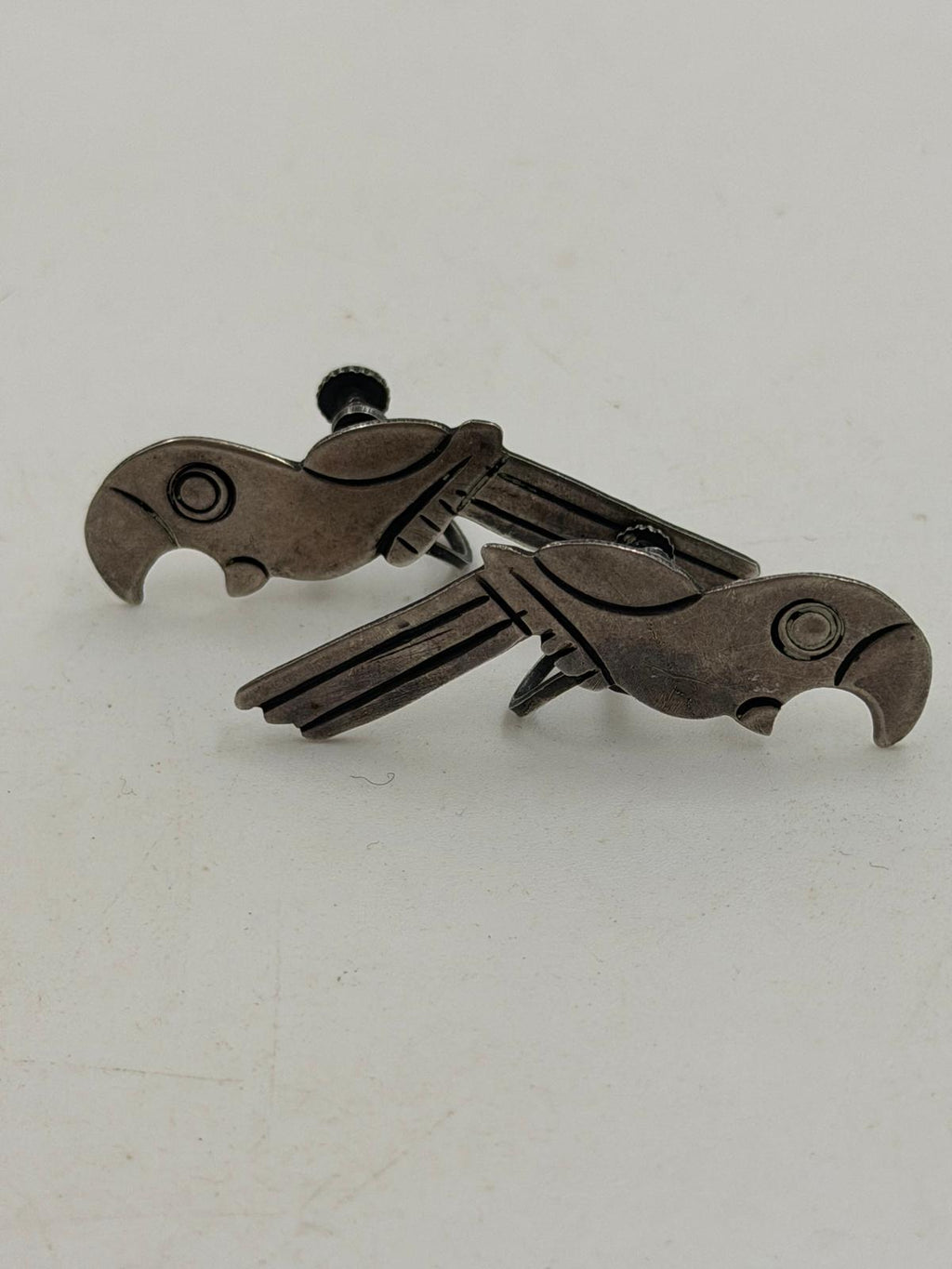 Vintage Mexican silver parrot earrings in hand - front view