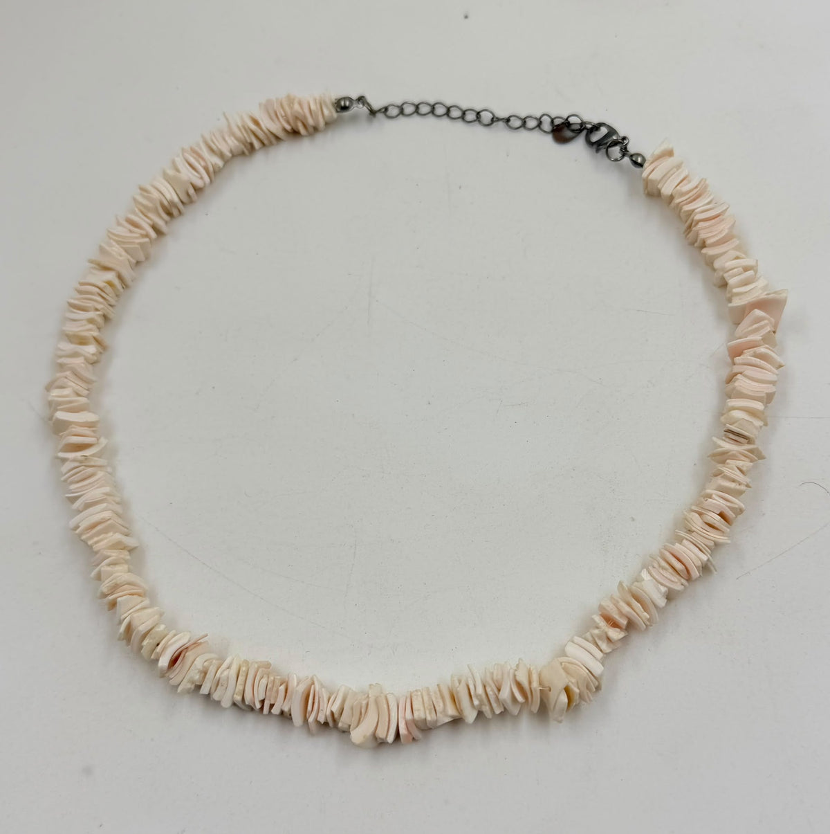 Close-up of pink shell slices and lobster claw clasp