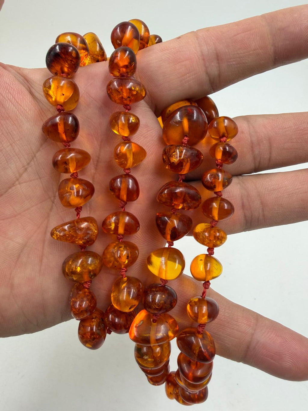 Necklace held in hand showing bead size and transparency