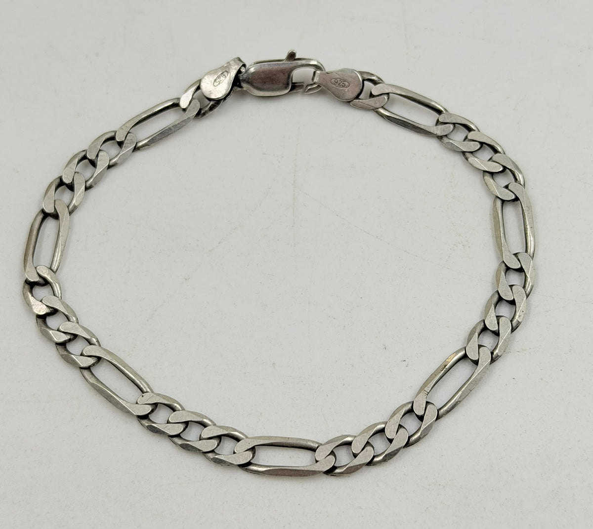 Silver Figaro bracelet flat lay on white background