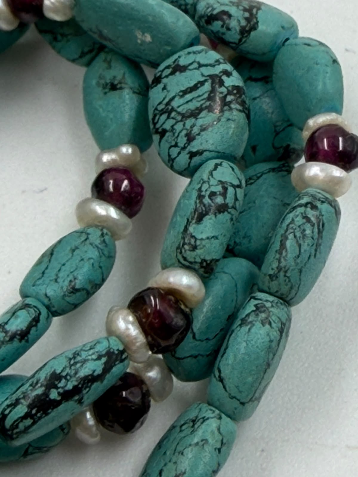 Natural turquoise garnet freshwater pearl necklace full view 44cm on woven surface with 925 silver clasp