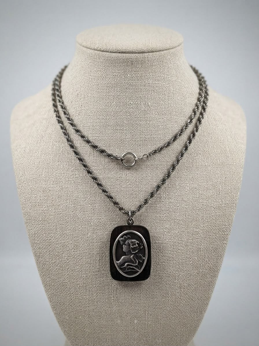 Back of wood cameo pendant with floral motif and ruler