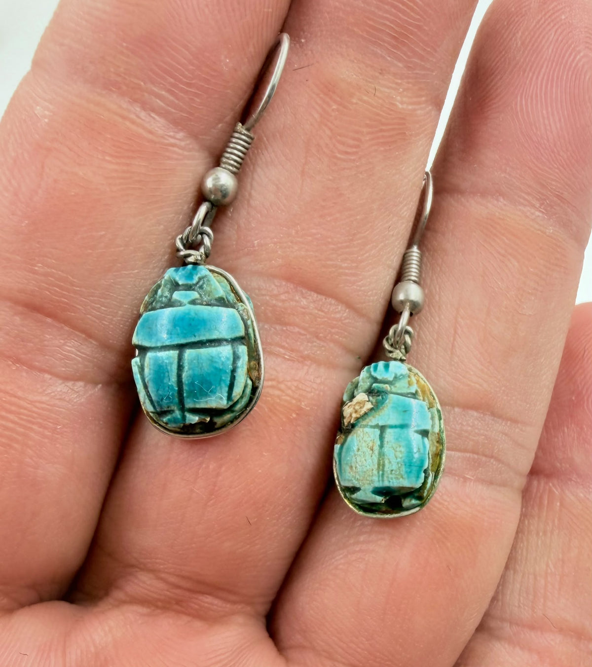 Scarab earrings pair on rattan showing turquoise color and size
