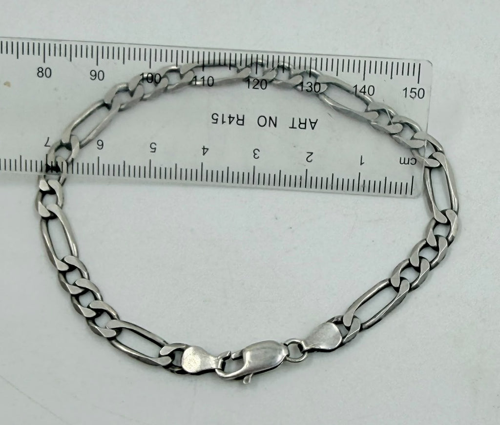 Silver Figaro bracelet on textured background