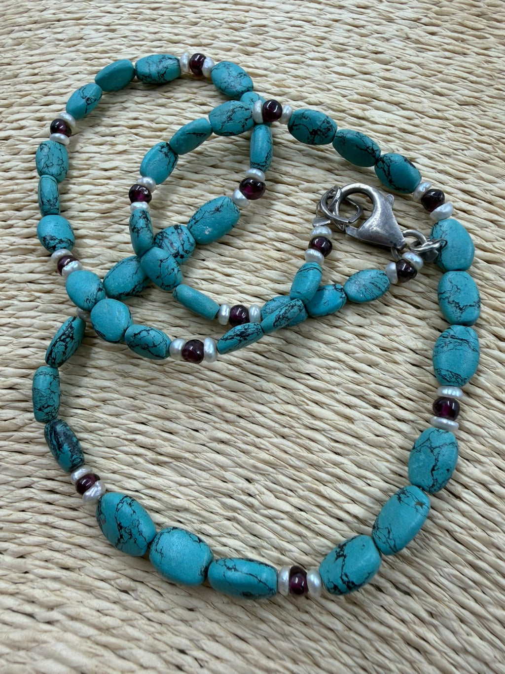 Natural turquoise garnet pearl necklace on white background full strand view