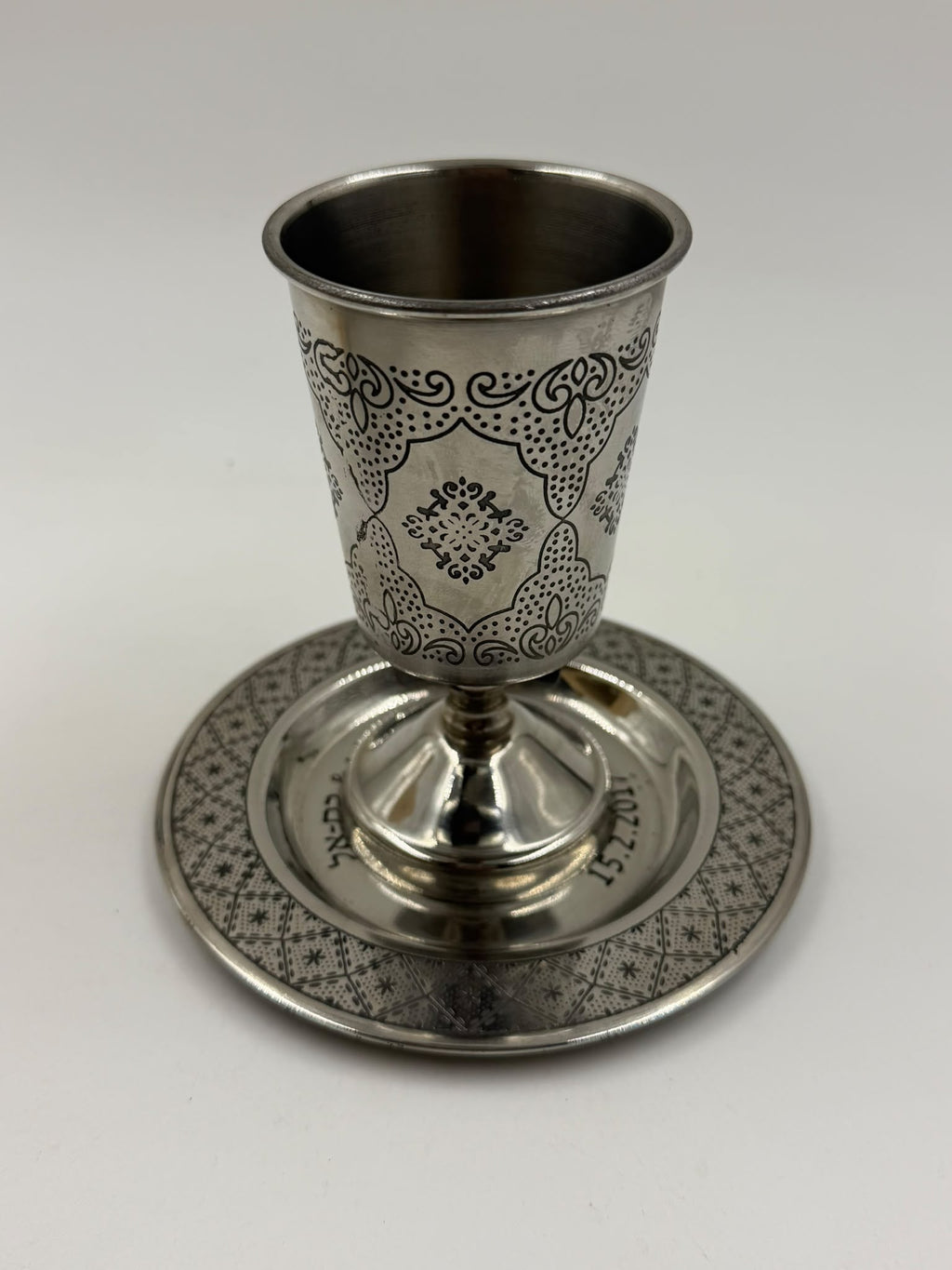 Israeli silver-plated Kiddush cup and saucer set tilted showing bottom of cup and saucer reverse