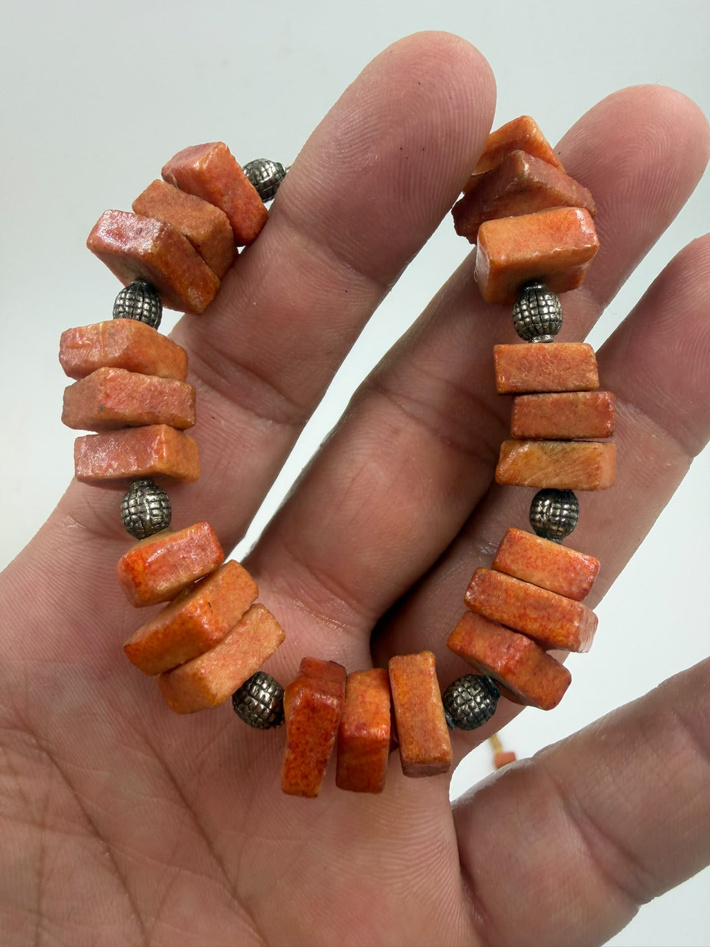 Natural coral bracelet close-up showing chunky beads and silver spacers