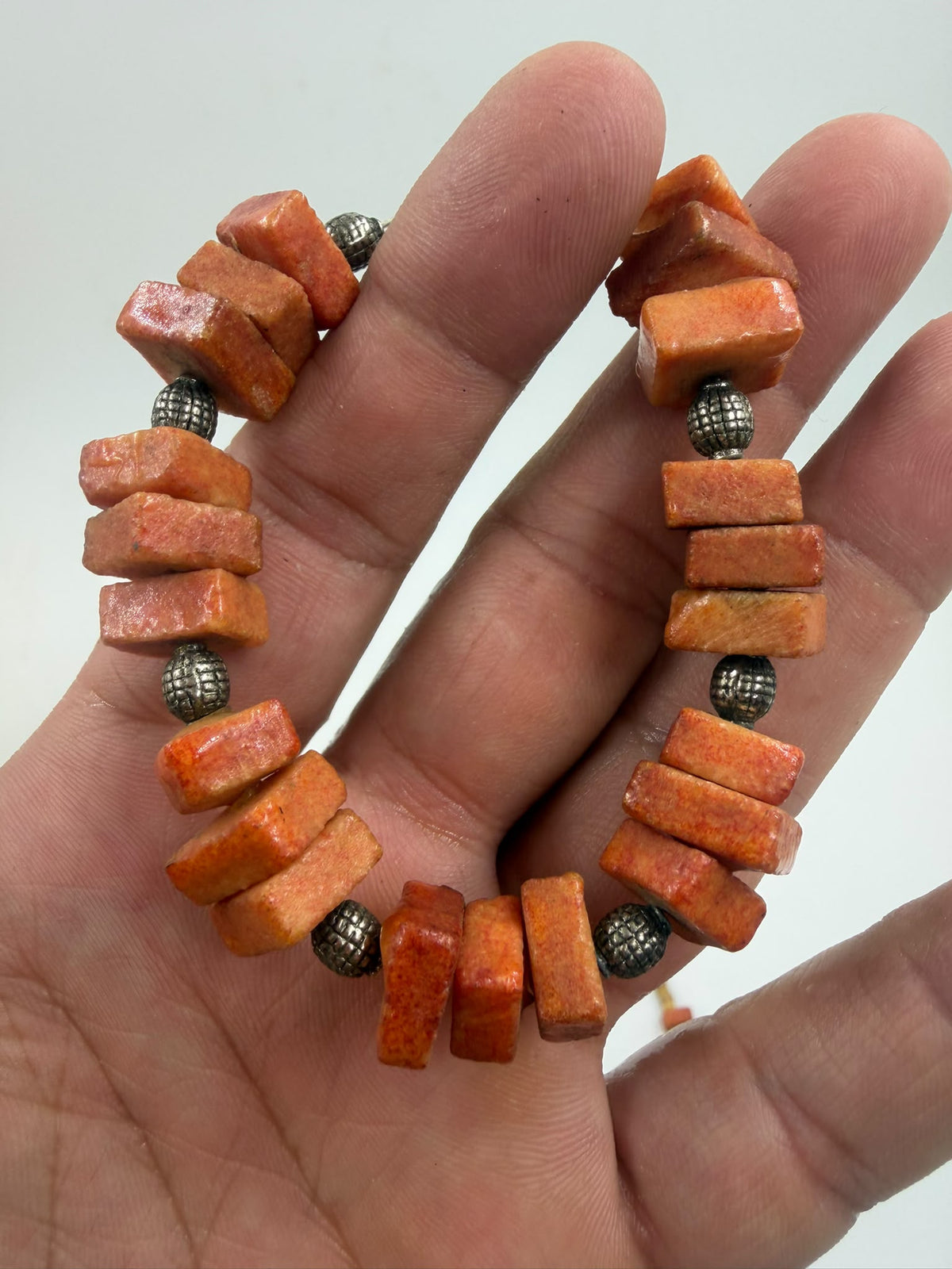 Natural coral bracelet close-up showing chunky beads and silver spacers