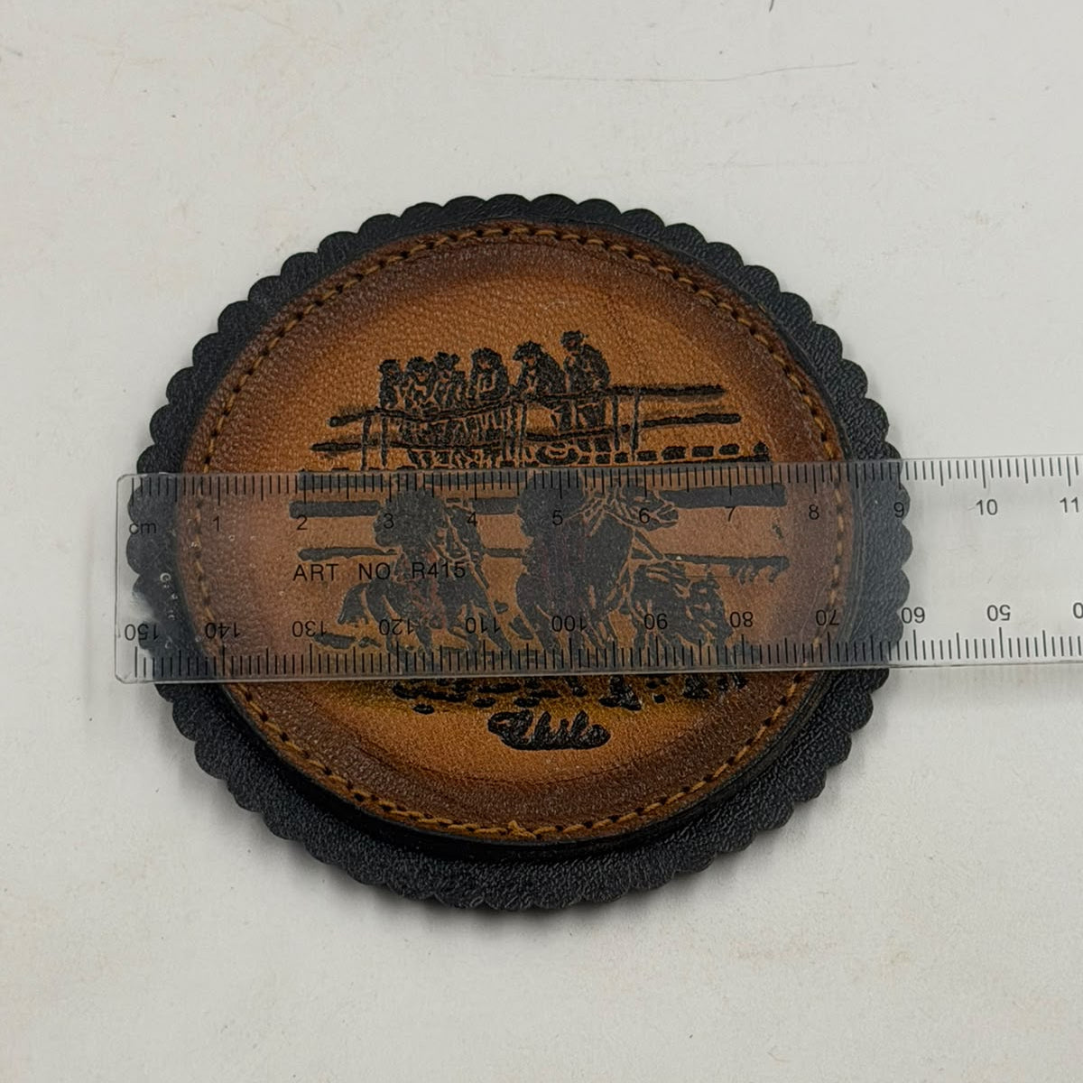 Chilean leather coaster showing farmer with oxen and Andean landscape