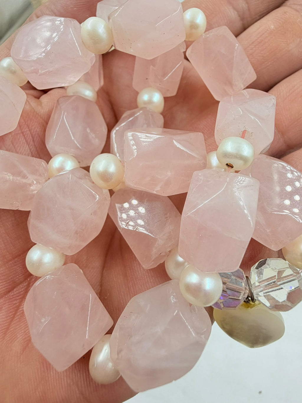 Rose quartz pearl necklace on jewelry display bust – side view