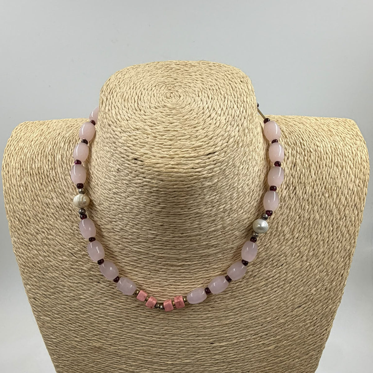 Rose quartz garnet bracelet held in palm showing full length 20cm with silver-tone tube spacers and 925 clasp