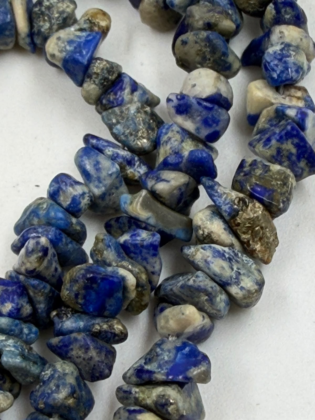 Natural lapis lazuli chip beads macro detail showing golden pyrite inclusions