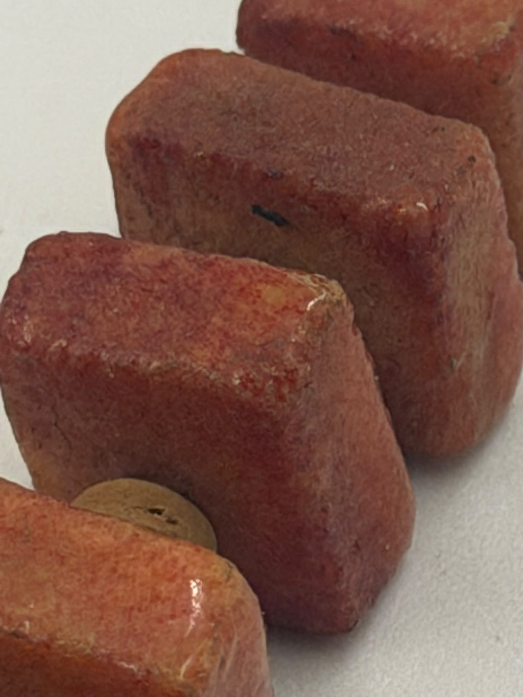 Natural coral tablet beads macro - showing raw texture and color variation