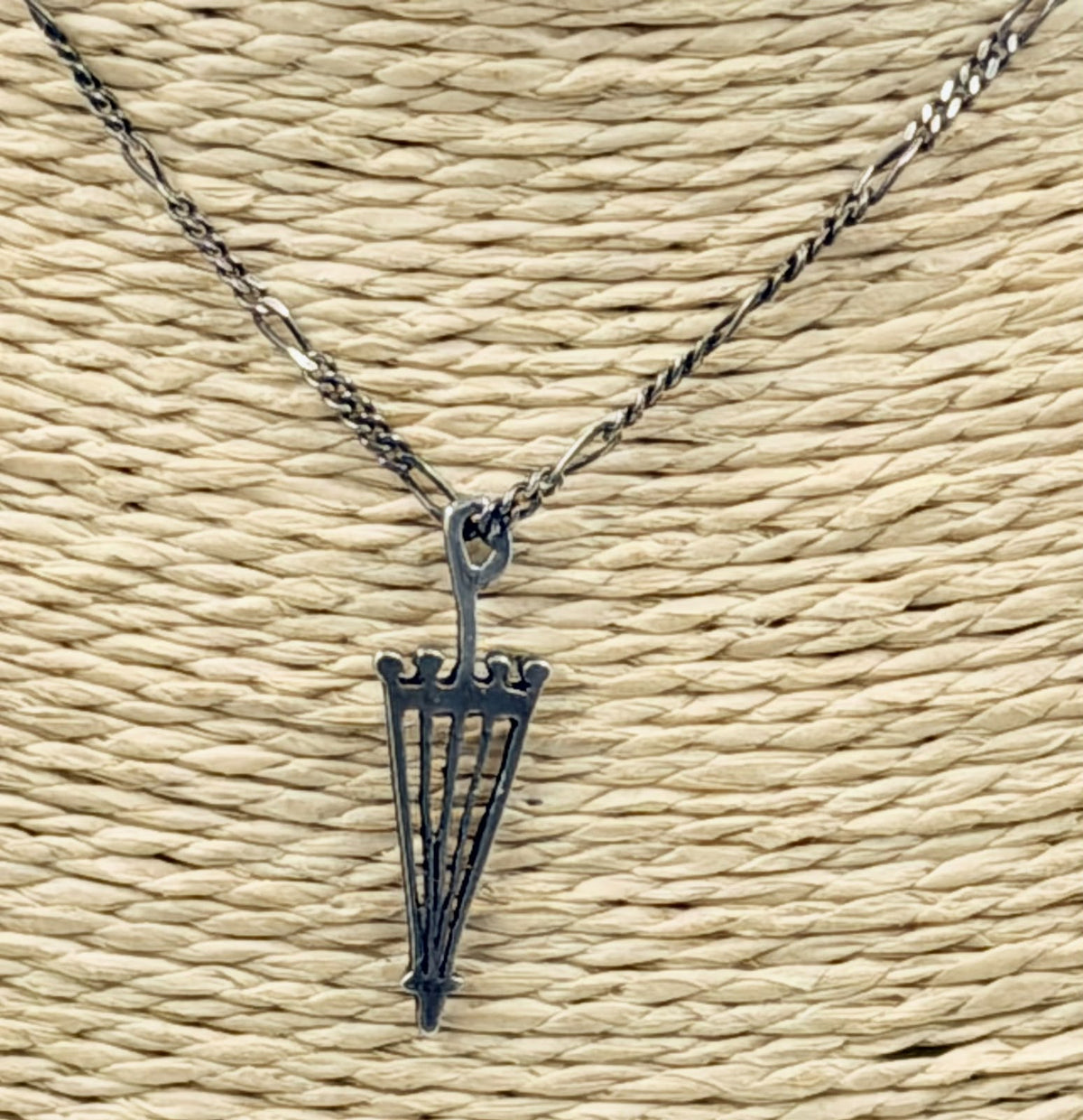 Silver umbrella pendant detail showing open-work bars
