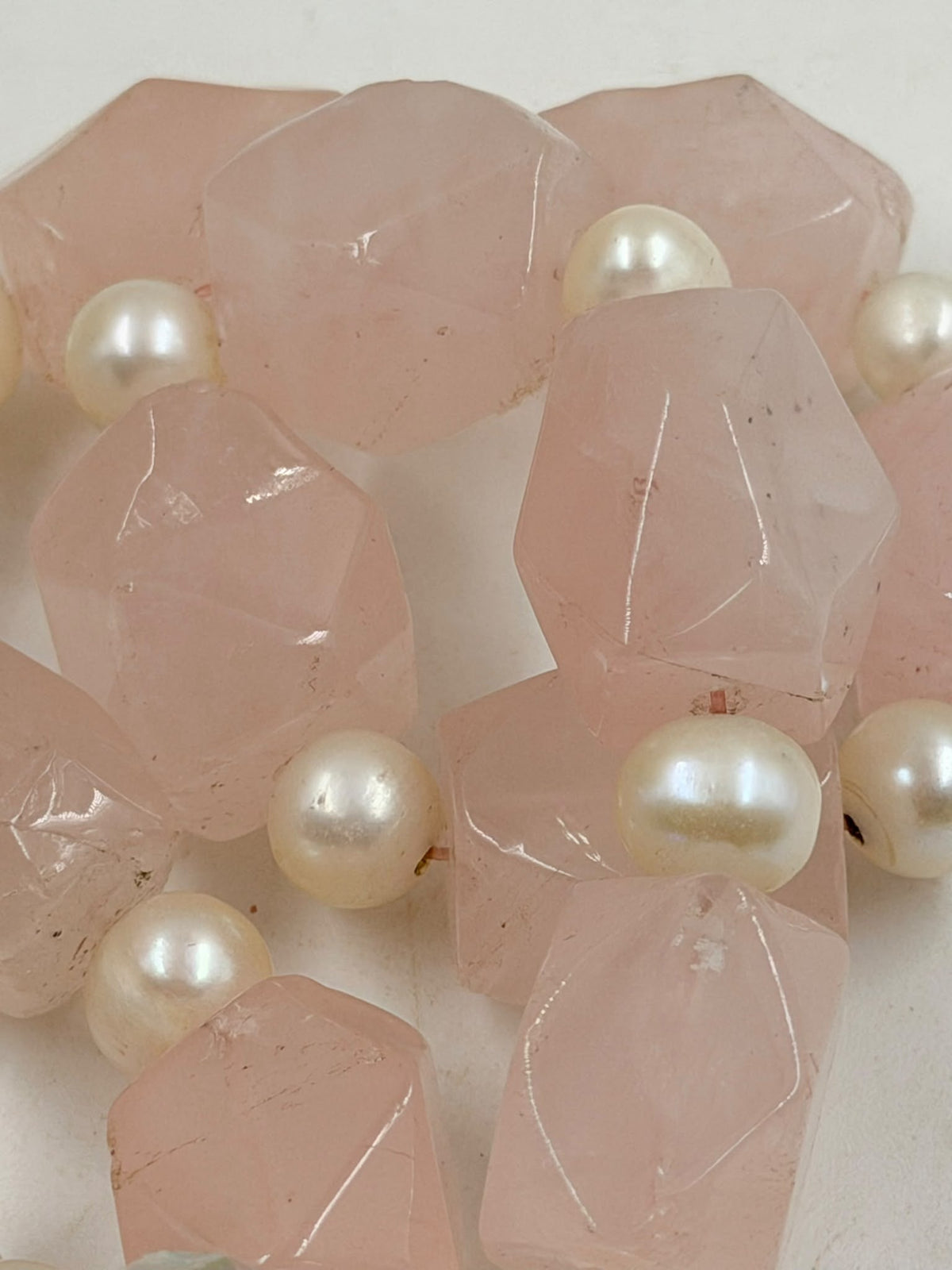 Rose quartz necklace beside ruler showing 24cm length