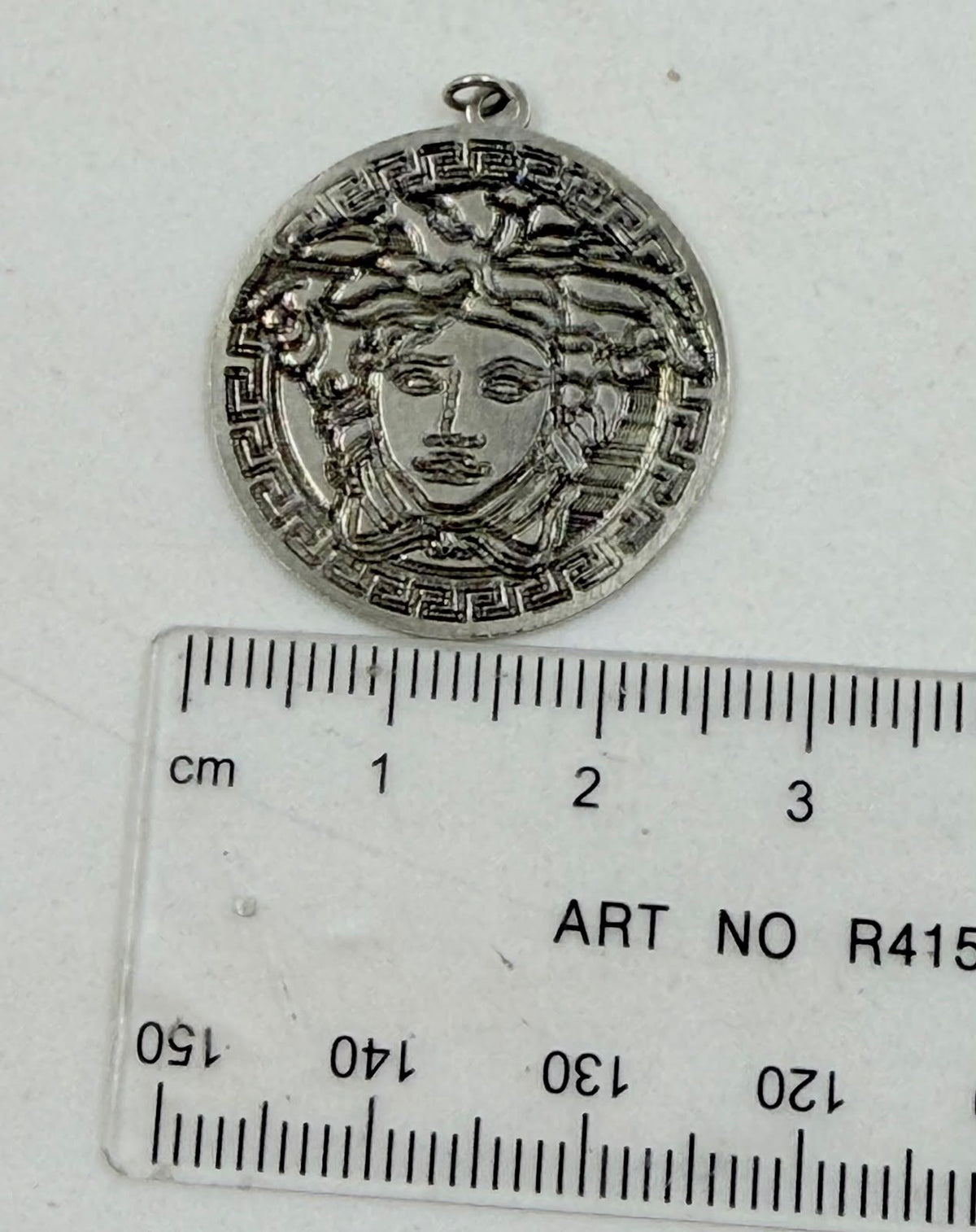 Medusa pendant on rattan background showing full design