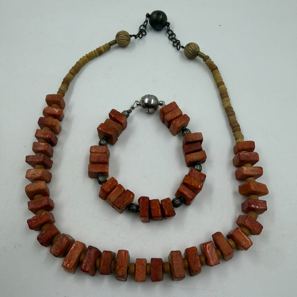 Natural coral necklace held in hand showing full drape
