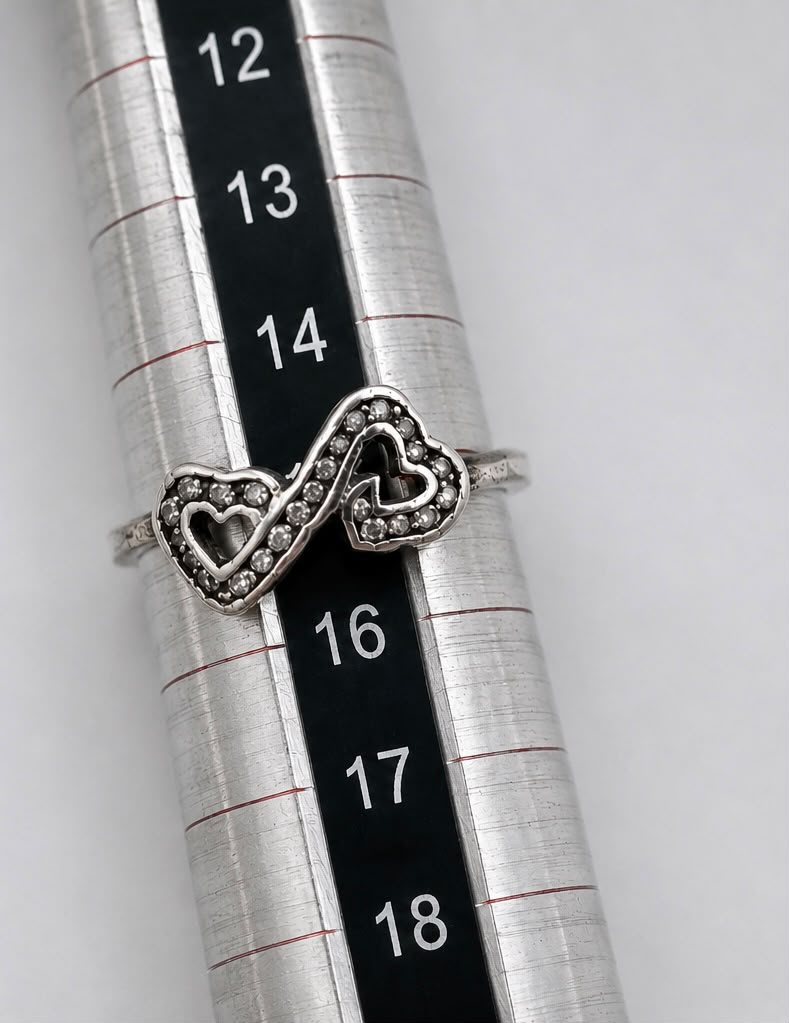 Sterling silver 925 double heart ring held between fingers showing full design