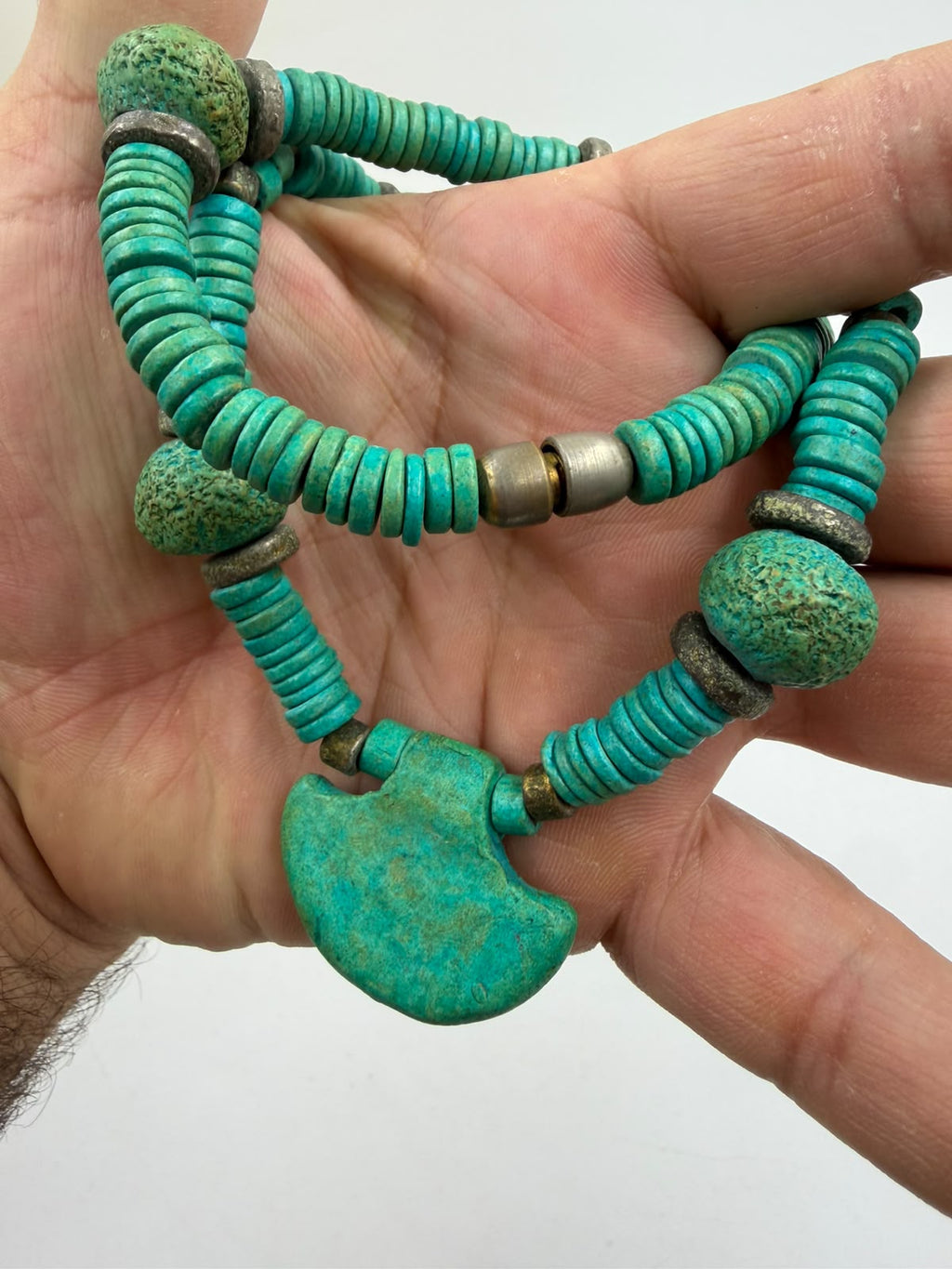 Natural turquoise heishi necklace held in hand showing size weight and fan shaped pendant