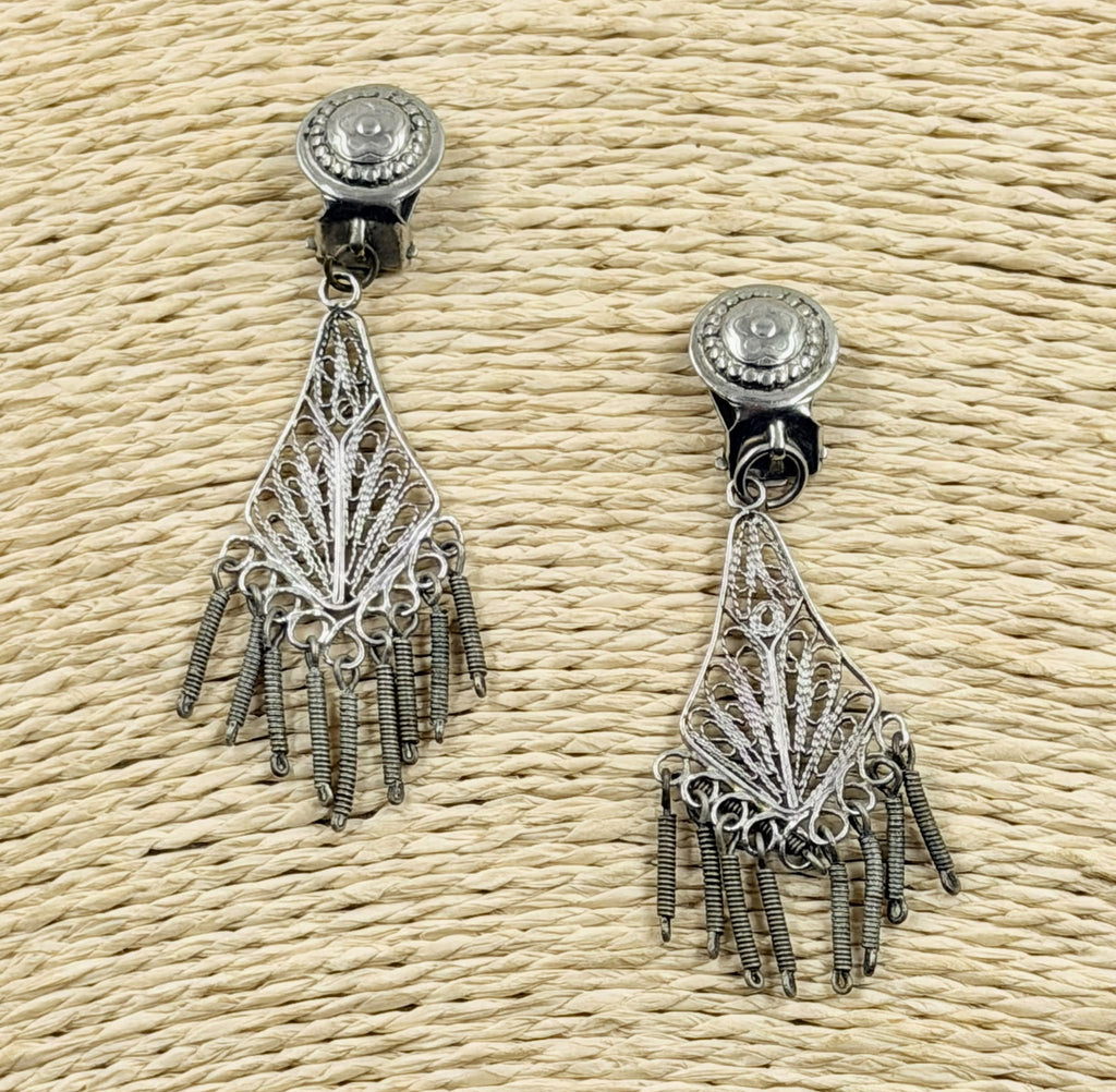 Silver filigree earrings pair showing fringe detail on rattan background