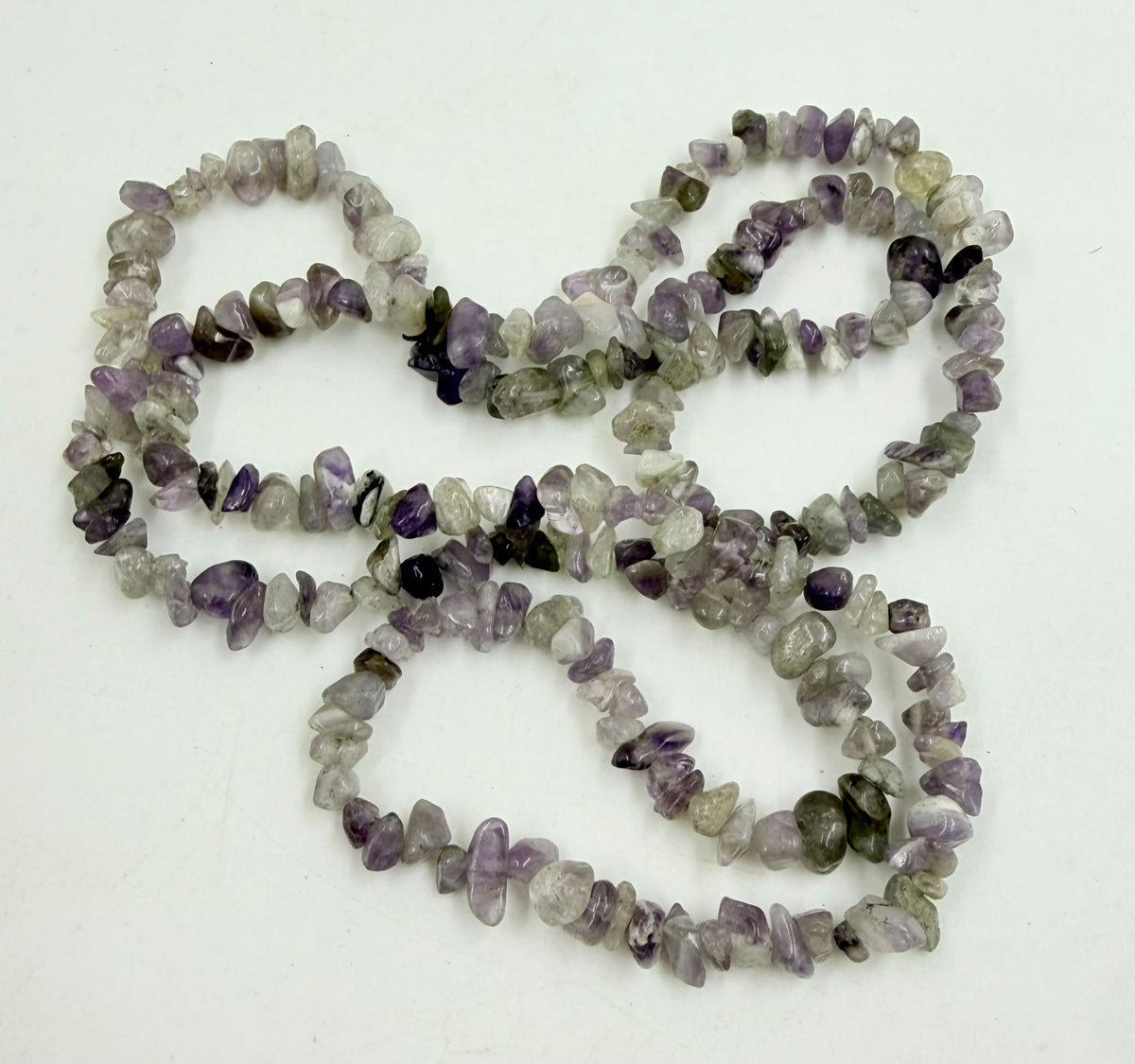 Natural amethyst chip necklace oval coil on white surface