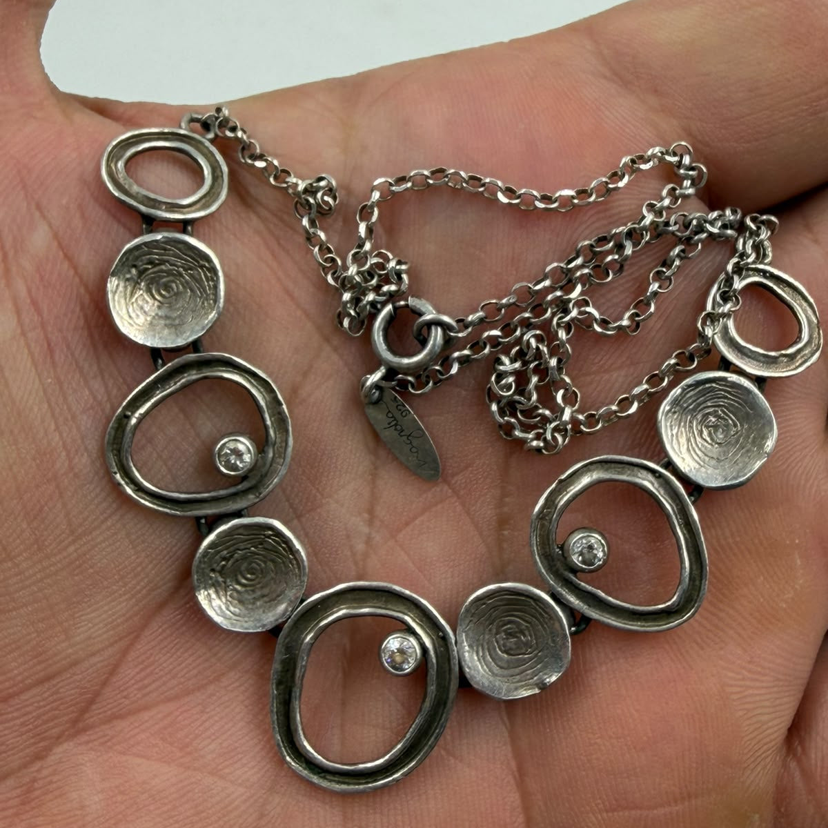 Full length view of oxidized silver necklace on display stand